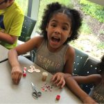excited girl makes paper fidget spinner