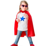 Child wearing red cape and white shirt with blue star on the front