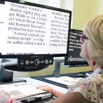 Woman reads a book using an adaptive reader