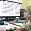 Woman reads a book using an adaptive reader