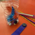 Clear plastic bottle of magnetic and non-magnetic items, magnet wand, and pipe cleaners